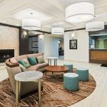 Modern, bright living room with neutral tones, fireplace, and contemporary furniture.