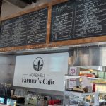 Menu boards displaying lunch and sandwich options above a cafe counter with "Hopewell Farmer's Cafe" signage.