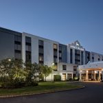 Modern Hyatt Place hotel exterior at dusk with illuminated entrance and landscaping.