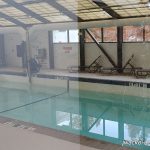 Indoor swimming pool with lane markers and a covered deck area.