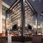 Modern bar area with a striking, illuminated glass and metal architectural feature.