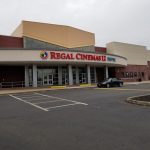 Regal Cinemas 12 movie theater exterior on a cloudy day with parking lot.