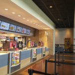 Fast food counter with digital menu boards in a modern, brightly lit restaurant.