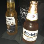 Corona Extra and Modelo Especial beers displayed next to a dark beverage in a glass.