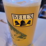 Glass of Bell's beer with a foamy head on a white surface.