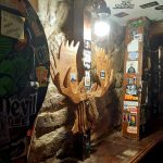 Wooden deer head sculpture displayed in a rustic, dimly lit bar setting.