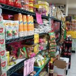 Grocery store aisle stocked with colorful snacks, chips, and packaged goods.