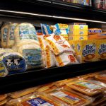 Shelves stocked with various packaged snacks and chips in a store display case.
