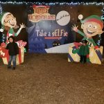 Family posing in front of a "Hamilton's Winter Wonderland" photo backdrop.