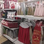 Holiday decor display featuring ornaments, festive clothing, and seasonal merchandise in a retail setting.