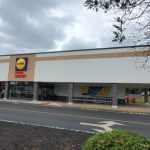 Lidl supermarket building under a cloudy sky with a road in the foreground.