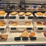 Assortment of fresh baked goods displayed in a refrigerated bakery case.