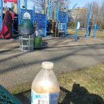 Yellow drink bottle in foreground with a colorful pirate-themed playground visible behind it.
