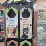 Dog adoption sign featuring pictures of a Yellow Lab and Doberman with pricing.