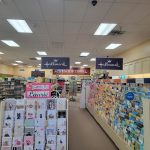 Retail store interior featuring Hallmark merchandise, cards, and gift items on shelves.