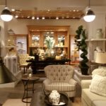 Luxury interior showroom with warm lighting, wooden accents, and stylish furniture displays.