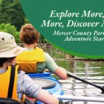 Family kayaking on a calm river surrounded by green trees and nature.