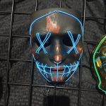 Black skull-like mask with glowing blue lines, displayed on a black wire grid.