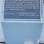 Vietnam Veterans United memorial stone with dedication text, set outdoors on pavement.