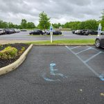 Accessible parking spot in a large outdoor parking lot under an overcast sky.