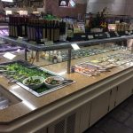 Refrigerated seafood and prepared food display counter in a grocery store.