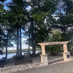 Outdoor dining area under trees with a stone archway labeled "Grandparents Grove."