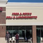 Fred & Pete's Deli storefront with people walking outside under a clear blue sky.