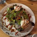 Gourmet salad with sliced tomatoes and mozzarella on a rustic plate.