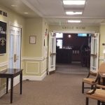 Hotel hallway leading to a grille room, featuring banquet hall signs and seating areas.