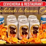 Ceviche platter with shrimp, lime, and chips surrounded by cans of Claro beverage.