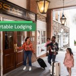 Family and woman stand outside a building entrance advertising "Comfortable Lodging."
