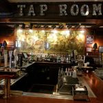 Tap room interior with a large historical mural above the bar area.