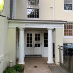 Entrance to Nassau Presbyterian Church with white columns and glass doors.
