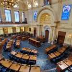 Ornate, grand assembly hall with tiered seating and high ceilings for formal meetings.