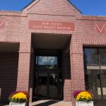 Exterior view of the New Jersey State Police Museum entrance under a clear blue sky.