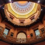 Ornate, multi-tiered interior atrium with a domed ceiling and detailed balconies.
