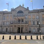 Grand neoclassical building facade on a sunny city street.
