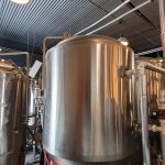 Stainless steel fermentation tanks in a brewery or production facility.