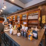 Bar area with wooden shelving, drinks, and counter service in a modern establishment.