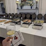 Buffet spread in a formal room with fireplace and artwork.