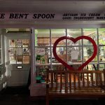 Exterior view of The Bent Spoon ice cream and bakery shop with a large heart cutout in the window.