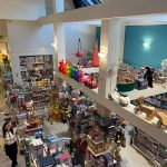 Multi-level toy store interior showcasing various toys, games, and merchandise displays.
