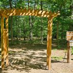 Wooden archway entrance to a forest trail near Walden Lake.