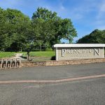 Princeton Country Club entrance sign with lush green trees and blue sky backdrop.