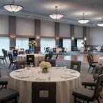 Elegant hotel ballroom set up for an event with round tables and formal seating.
