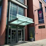 Princeton Public Library entrance with brick facade and banner advertising the library.