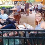 Group of people relaxing and socializing at an outdoor cafe patio.