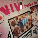 Vivid, colorful mural featuring bubble tea and vibrant artwork in a cafe setting.