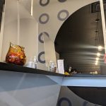 Modern interior design featuring a curved wall with circular patterns and a service counter.