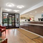 Modern lobby area with reception desk, seating, and glass entrance doors.